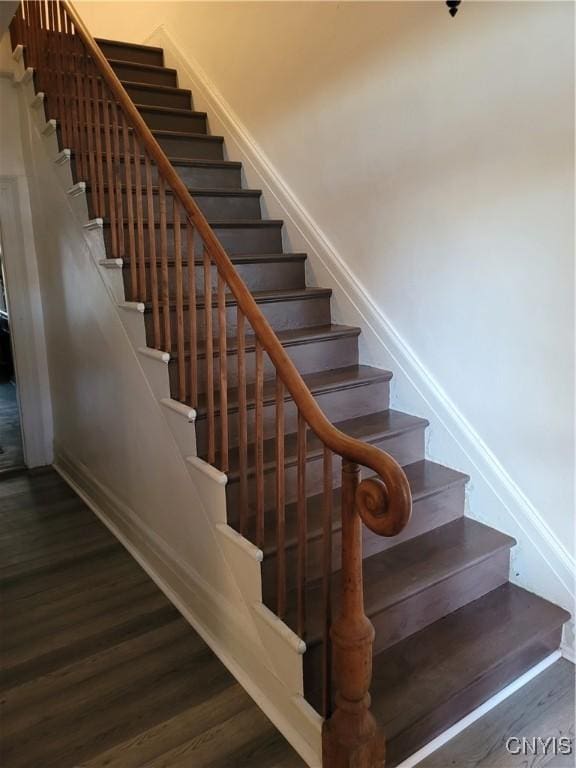 stairway with baseboards and wood finished floors