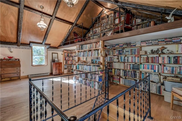 hall with a baseboard heating unit, wood finished floors, and vaulted ceiling with beams