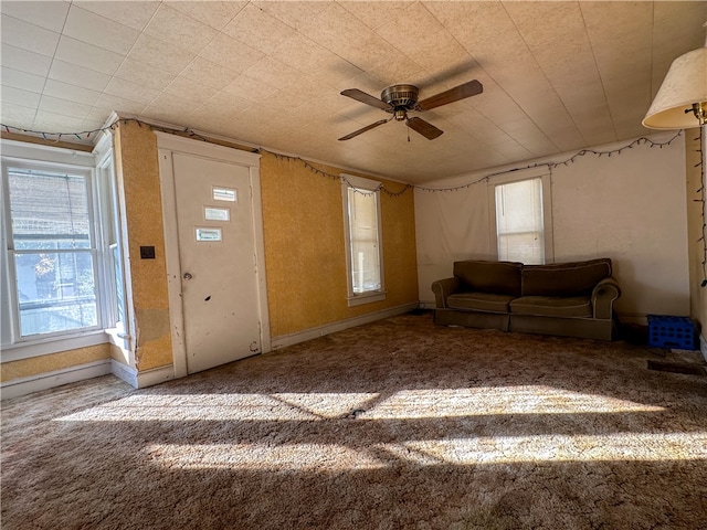 unfurnished living room with carpet and ceiling fan