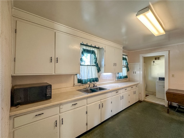 kitchen featuring washer / clothes dryer, white cabinetry, sink, and crown molding