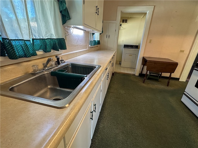 kitchen featuring white cabinetry, washer / clothes dryer, and sink