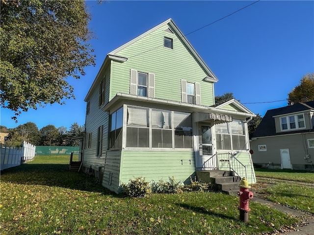 view of property with a front yard and a sunroom