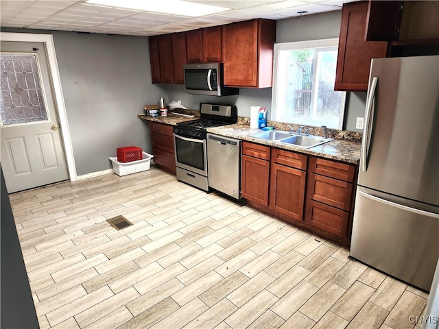 kitchen featuring light hardwood / wood-style floors, appliances with stainless steel finishes, sink, and a paneled ceiling