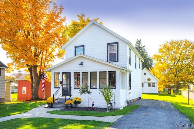 view of front of property with a yard and a shed