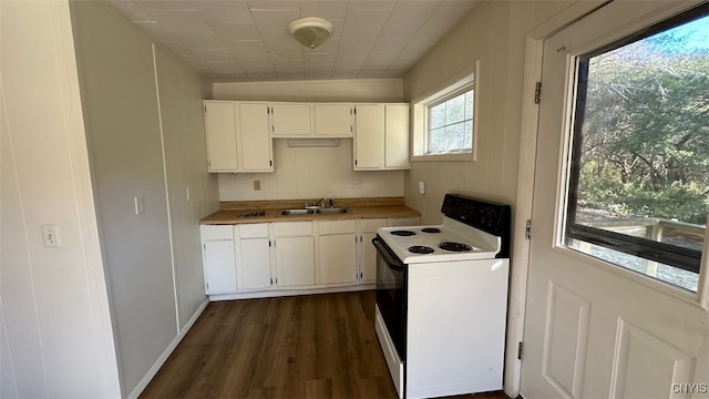 kitchen featuring dark wood-type flooring, white electric range, sink, and white cabinets