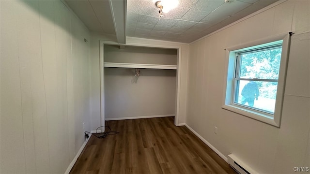 interior space with dark hardwood / wood-style flooring and a baseboard heating unit