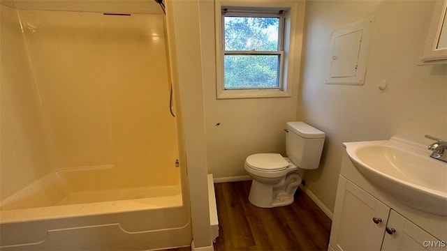 full bathroom featuring electric panel, hardwood / wood-style flooring, toilet, vanity, and tub / shower combination