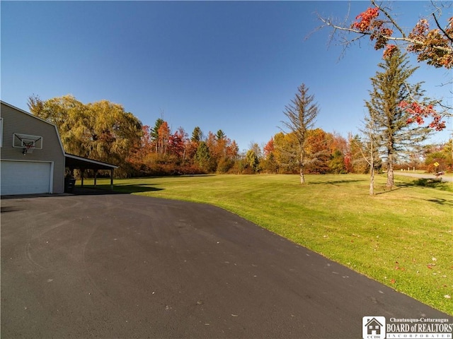 view of yard featuring a garage and a carport