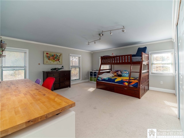 bedroom with carpet floors, multiple windows, crown molding, and track lighting