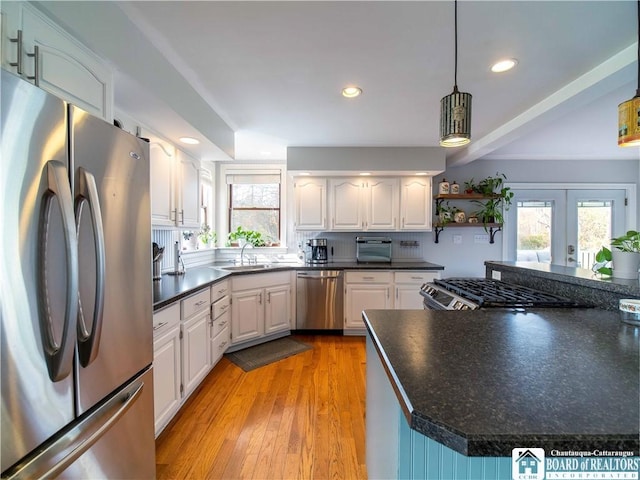 kitchen featuring a sink, dark countertops, white cabinetry, and stainless steel appliances