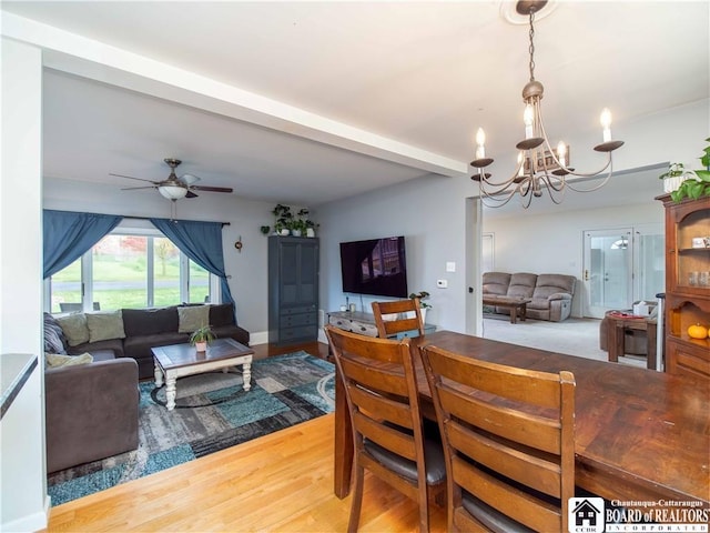 dining area with beam ceiling, ceiling fan with notable chandelier, and wood finished floors