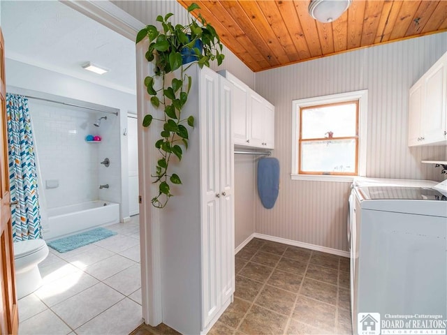 laundry area featuring washer and clothes dryer, cabinet space, wooden ceiling, light tile patterned floors, and baseboards