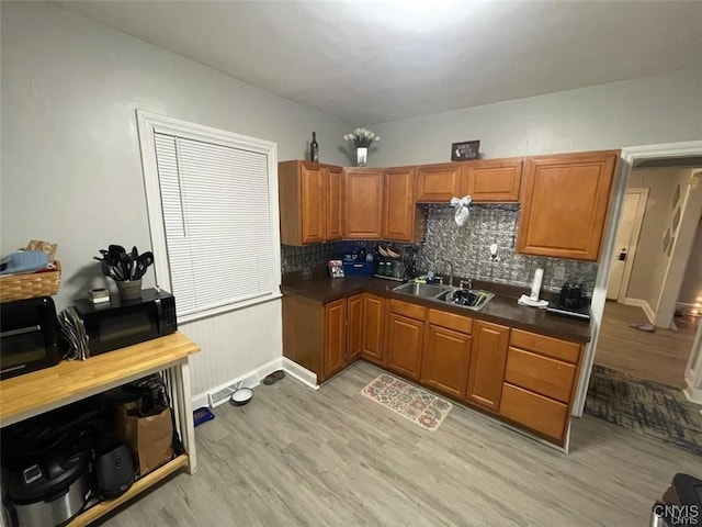 kitchen featuring backsplash, sink, and light wood-type flooring