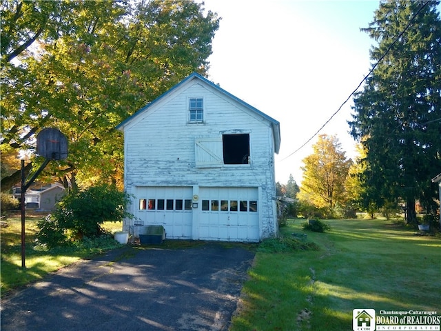 exterior space with a garage and a lawn