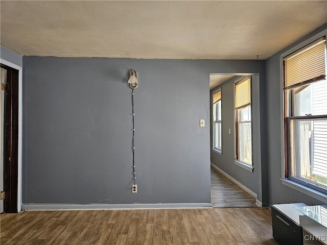 spare room with hardwood / wood-style floors and a textured ceiling