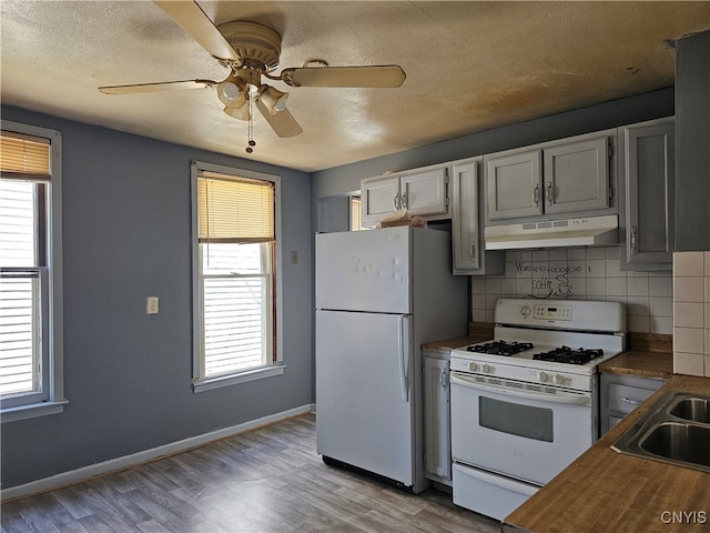 kitchen with light hardwood / wood-style flooring, a healthy amount of sunlight, and white appliances