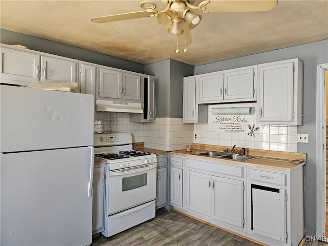 kitchen featuring decorative backsplash, white cabinetry, hardwood / wood-style floors, and white appliances