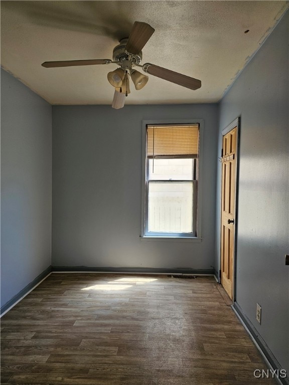 unfurnished room featuring ceiling fan, a textured ceiling, and dark hardwood / wood-style floors