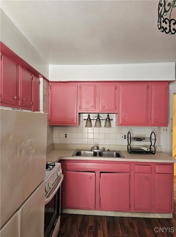 kitchen with stainless steel fridge, tasteful backsplash, sink, and range with electric cooktop