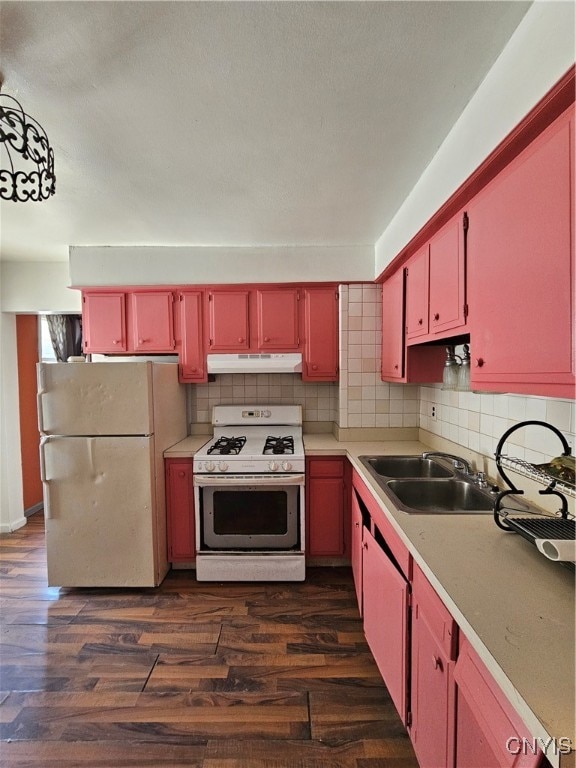 kitchen featuring backsplash, sink, dark wood-type flooring, and white appliances