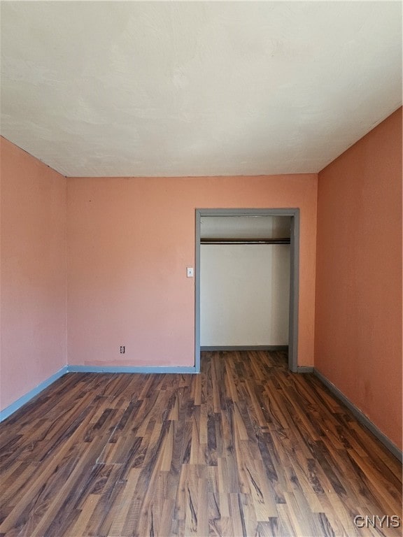 unfurnished bedroom featuring a closet and dark hardwood / wood-style floors