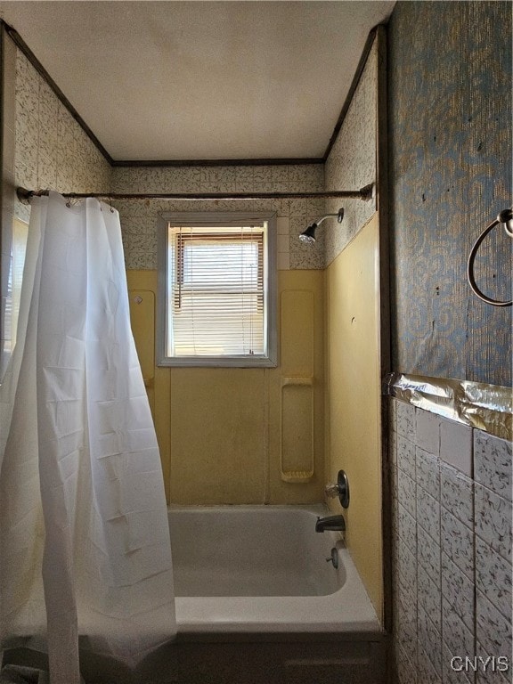 bathroom with ornamental molding, shower / bathtub combination with curtain, and a textured ceiling