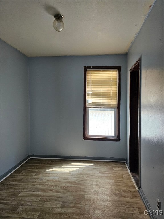 unfurnished room with wood-type flooring