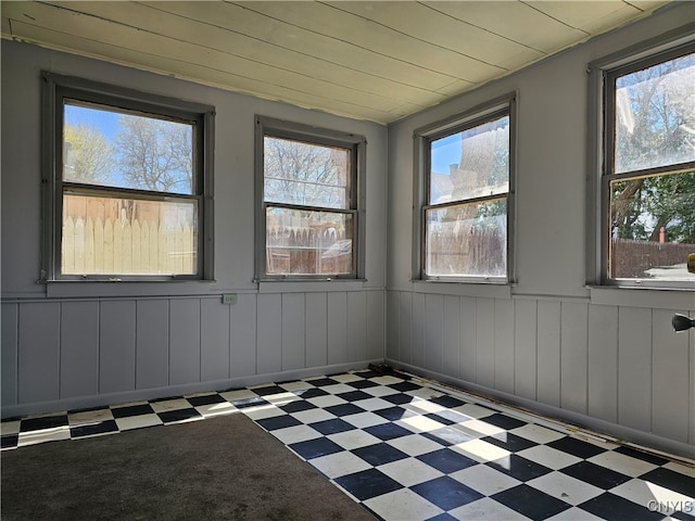 unfurnished sunroom with wood ceiling and plenty of natural light