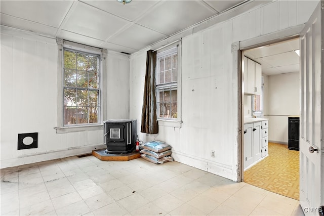 unfurnished room featuring a wood stove