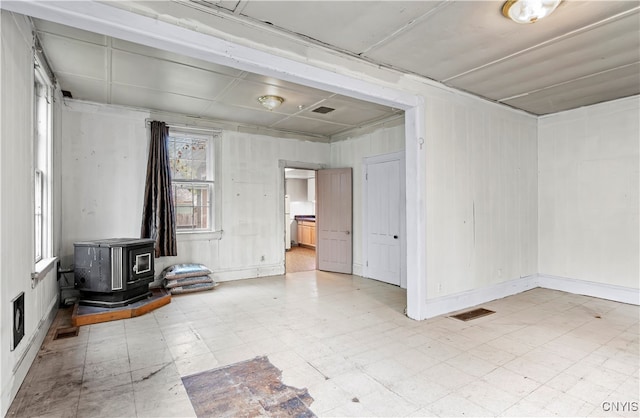 unfurnished room featuring a wood stove