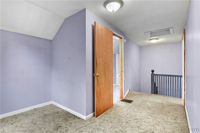 hallway with vaulted ceiling and carpet floors