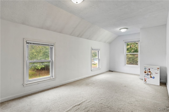 bonus room with a textured ceiling, carpet flooring, and vaulted ceiling