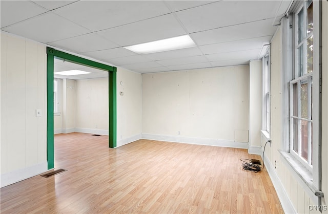 unfurnished room with a drop ceiling and wood-type flooring