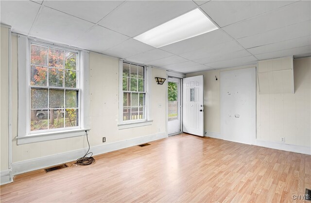 unfurnished room with light hardwood / wood-style floors and a paneled ceiling