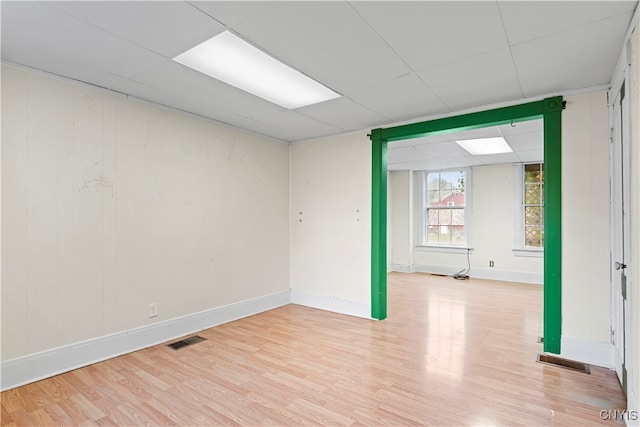 unfurnished room with wooden walls and light wood-type flooring