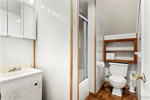 full bathroom with parquet flooring, toilet, tile walls, bath / shower combo with glass door, and vanity