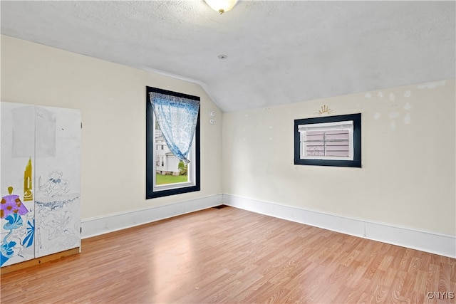 bonus room featuring lofted ceiling, a textured ceiling, and wood-type flooring