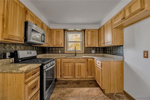 kitchen with light brown cabinets, sink, appliances with stainless steel finishes, and tasteful backsplash