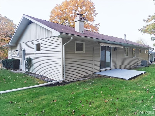 back of property featuring a yard, central AC unit, a chimney, and a patio area