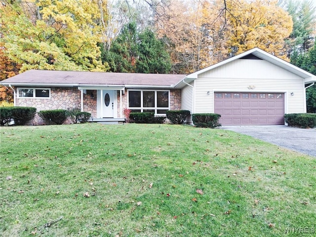 ranch-style house featuring stone siding, concrete driveway, an attached garage, and a front yard