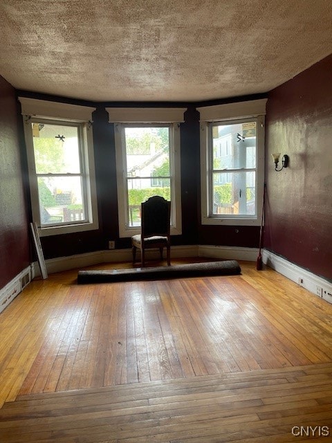 unfurnished room featuring hardwood / wood-style floors and a textured ceiling