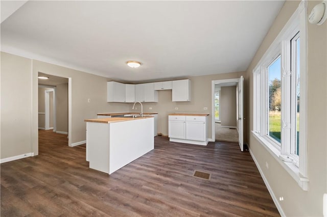 kitchen with dark wood-type flooring, a healthy amount of sunlight, and white cabinets