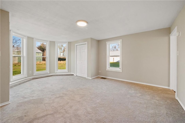 carpeted empty room with a healthy amount of sunlight