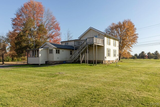 rear view of property with a deck and a yard