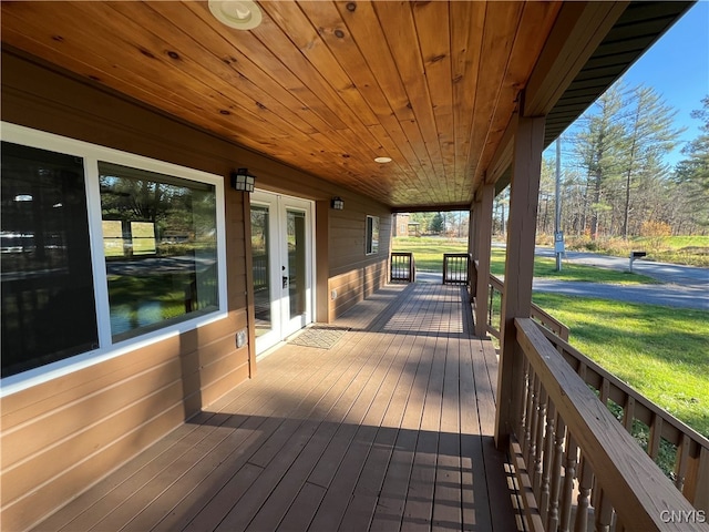 wooden deck featuring french doors and a lawn