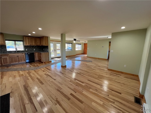 unfurnished living room with light hardwood / wood-style floors, sink, and ceiling fan