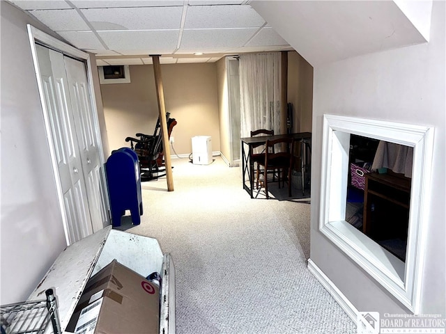 interior space featuring light colored carpet and a paneled ceiling