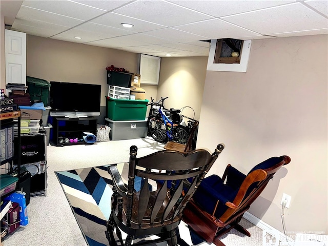 carpeted office with a paneled ceiling