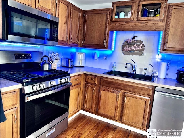 kitchen featuring sink, dark wood-type flooring, stainless steel appliances, and backsplash