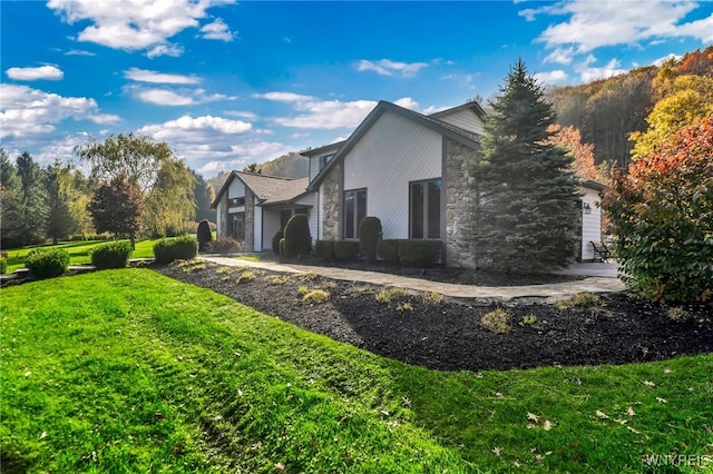 view of side of home featuring a lawn and a garage